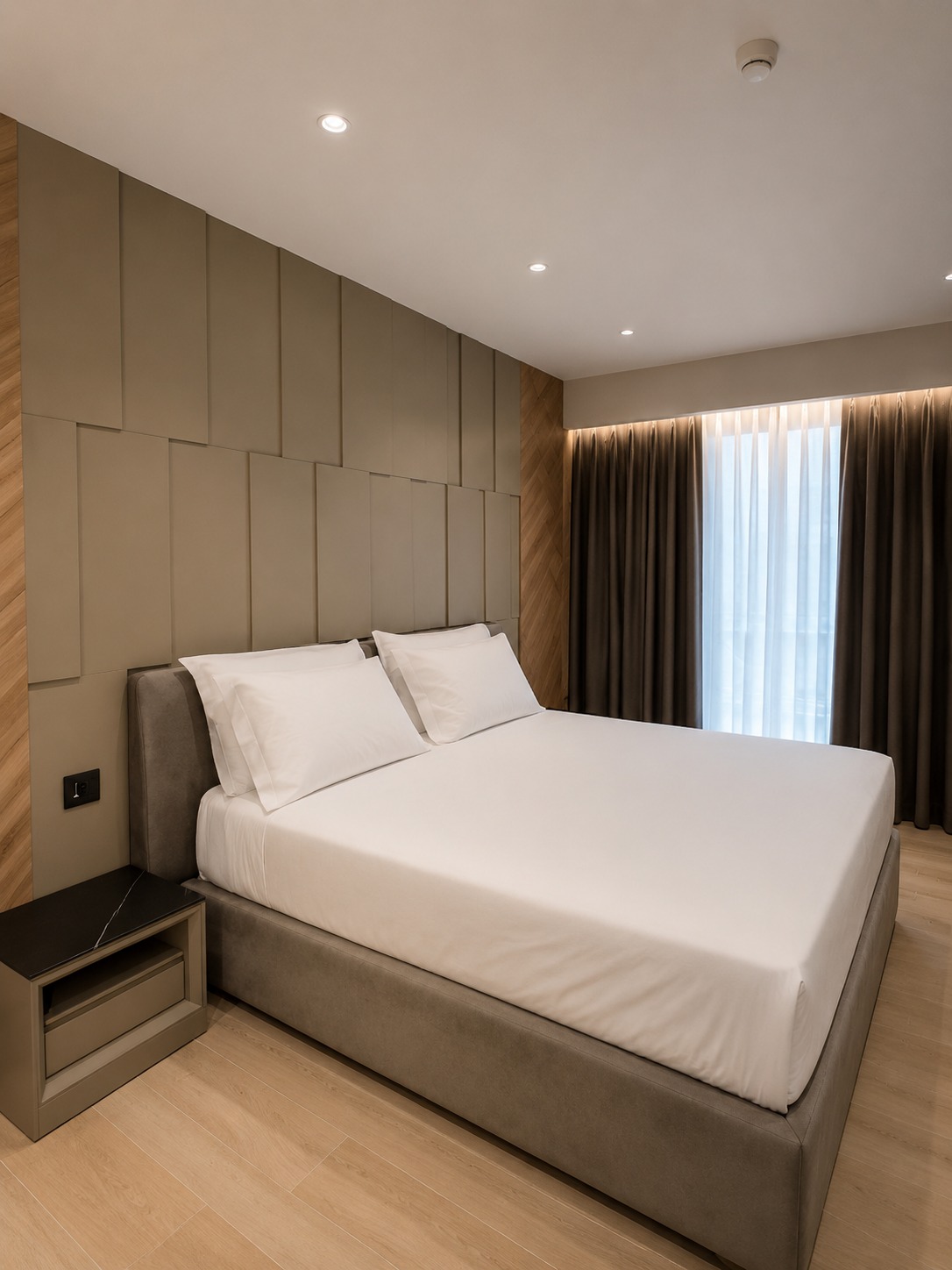 Bespoke bedroom with taupe wall panels, an upholstered bed and oak flooring